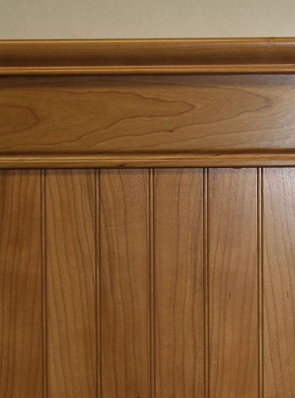 A close up look at natural stained cherry hardwood beadboard