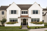 Elegant two-story white house with round fiberglass columns, arched entry door, and PVC window shutters.